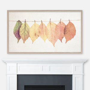Watercolor painting of colorful autumn leaves on a thread displayed in Samsung Frame TV above fireplace