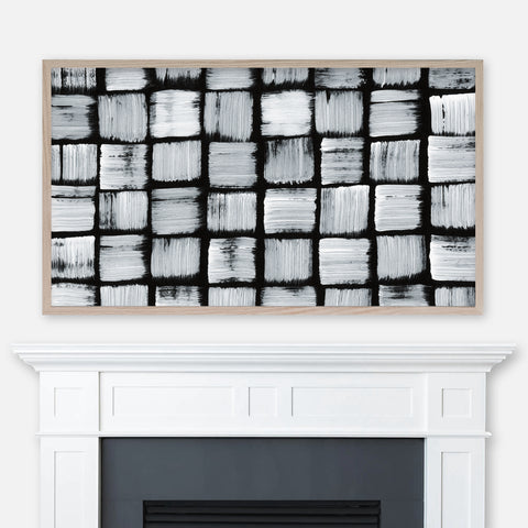 Abstract black and white square dots pattern painting displayed in Samsung Frame TV above fireplace