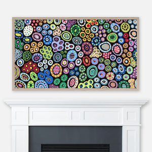 Colorful circles and dots abstract graffiti pattern painting displayed in Samsung Frame TV above fireplace