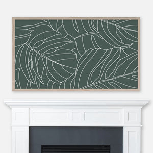 Forest green and white monstera leaf pattern line art displayed full screen in Samsung Frame TV above fireplace