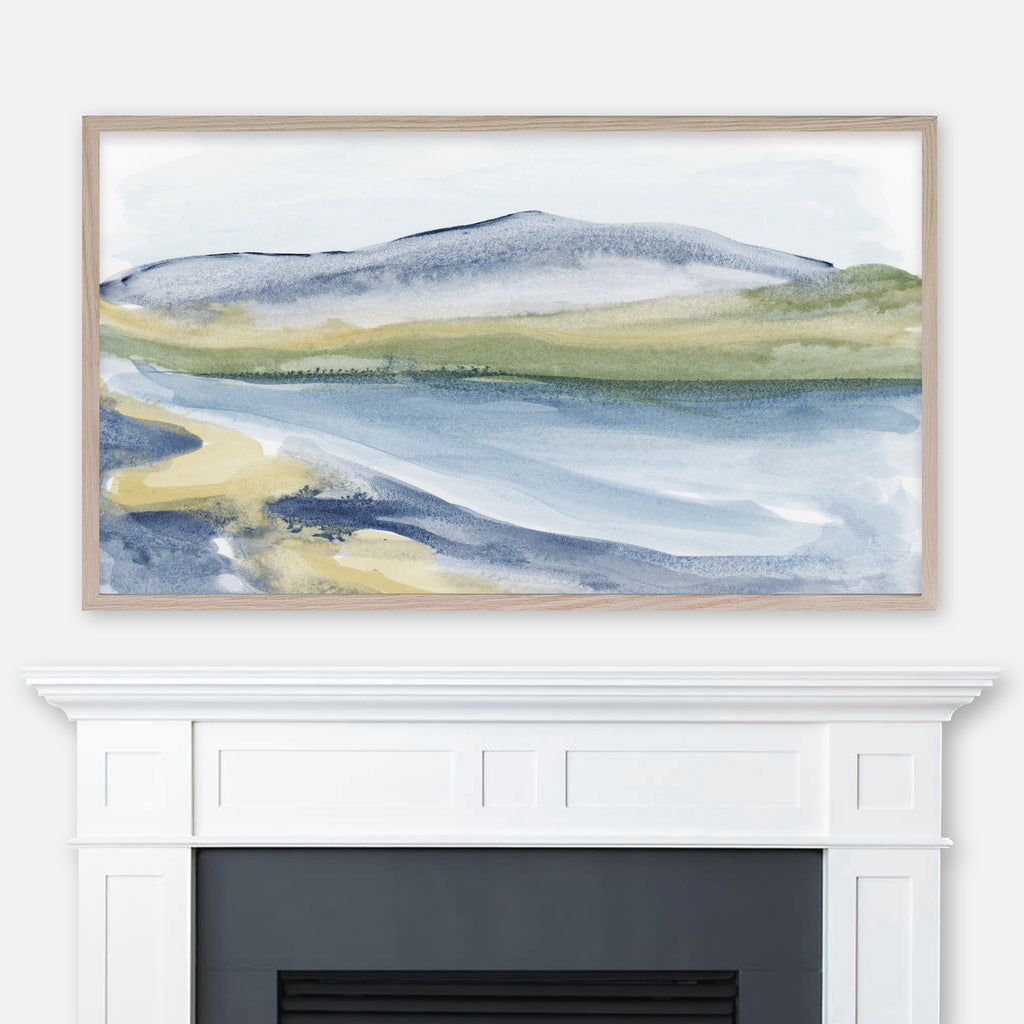 Blue and green mountain and lake watercolor landscape painting displayed full screen in Samsung Frame TV above fireplace