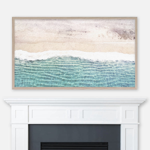 Watercolor coastal landscape painting of an aerial view of ocean waves on a beach displayed in Samsung Frame TV above fireplace