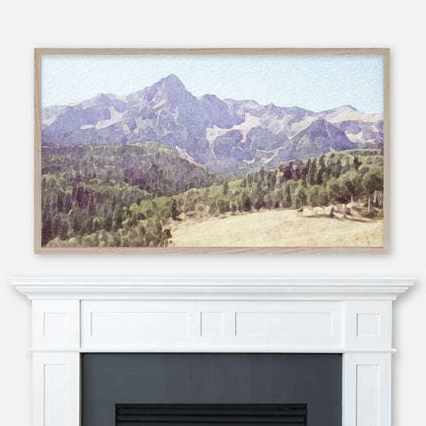 Watercolor painting of Colorado mountains pine trees and meadow landscape displayed in Samsung Frame TV above fireplace