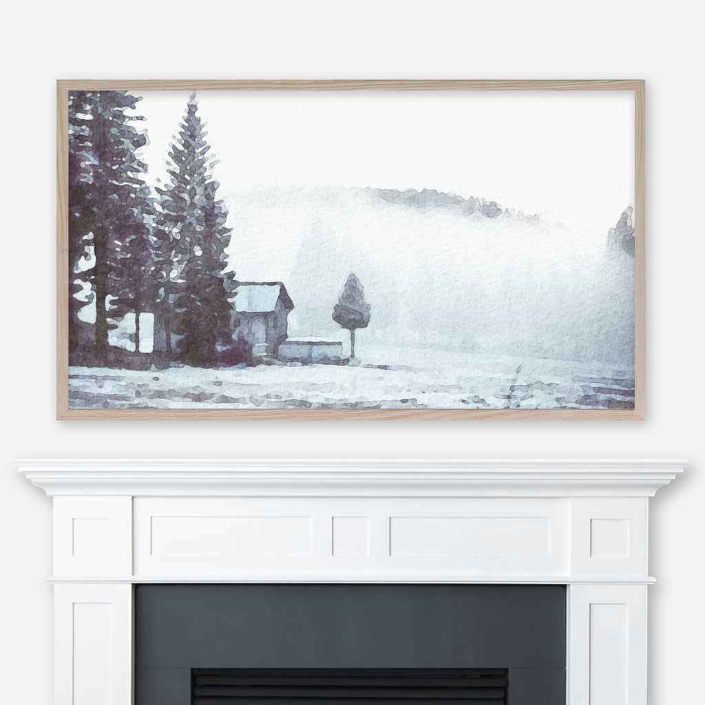 Watercolor winter landscape painting of a cabin in snow with pine trees and foggy mountain displayed in Samsung Frame TV above fireplace
