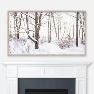 Watercolor winter landscape painting of snowy leafless trees on a bright day displayed in Samsung Frame TV above fireplace